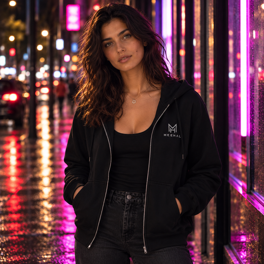 Maya wearing the black MEEHAL Signature Zip Hoodie on a neon-lit street at night